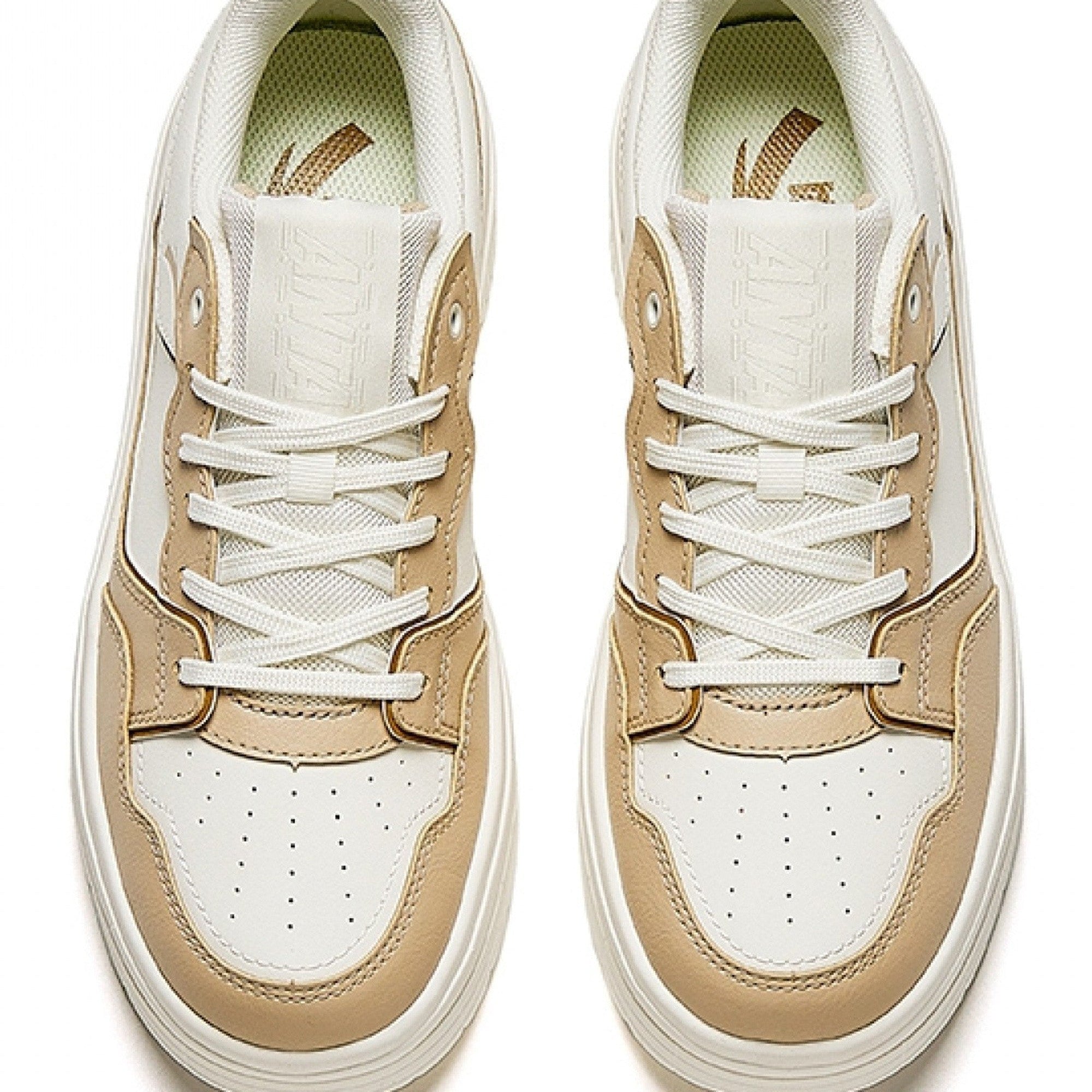Pair of beige and white sneakers on a white background